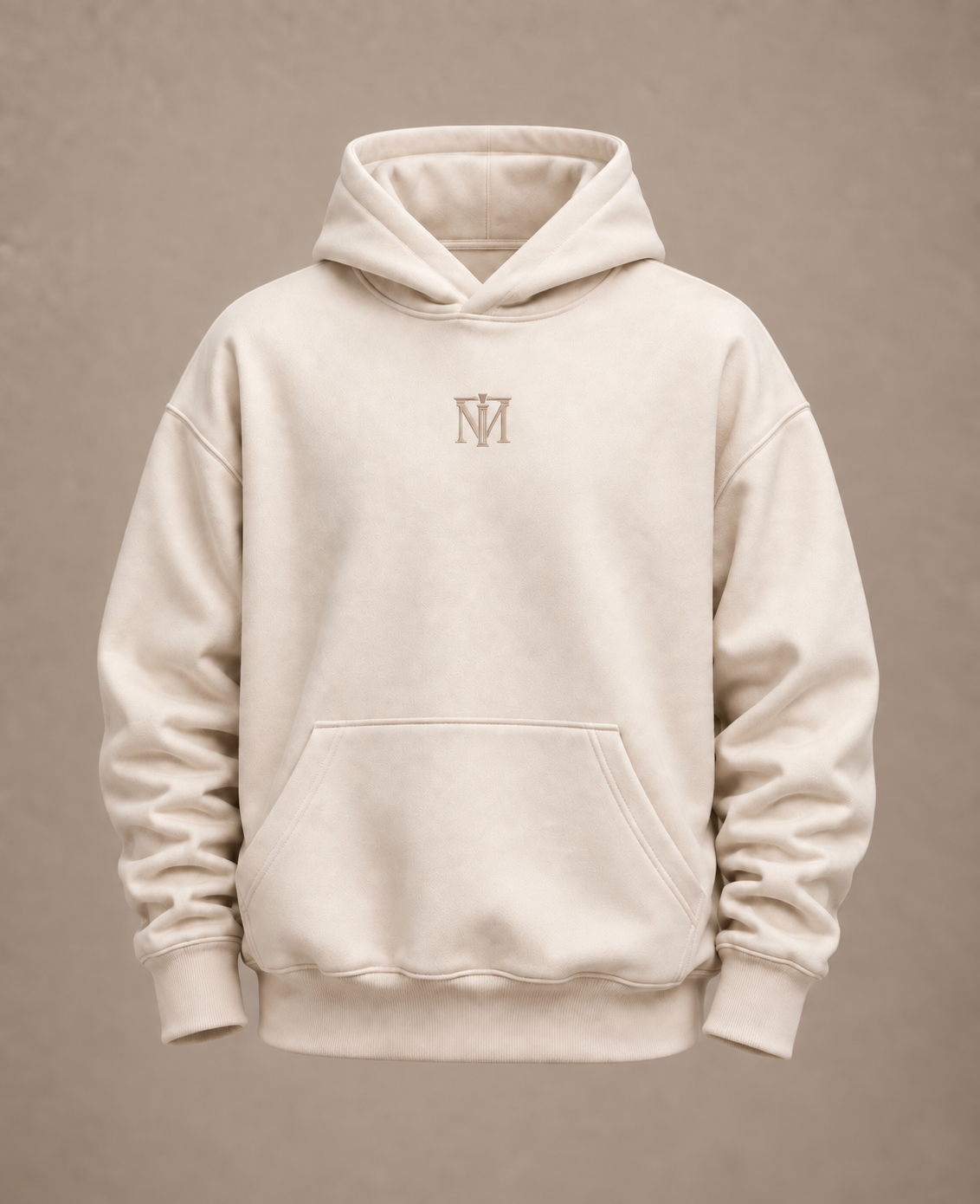 A cream-colored pullover hoodie with a small embroidered 'M' logo on the center chest, displayed against a neutral beige background.